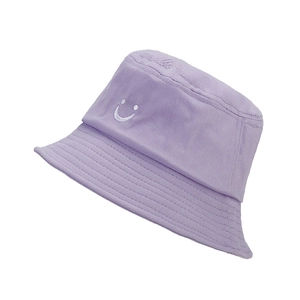 Detail of light purple cotton bucket hat with white embroidered smiley face on white background