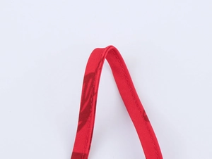 Detailed macro view of the red palm leaf fabric strap with neat stitching and texture