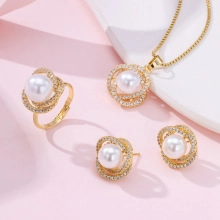Close-up of golden jewelry set featuring white pearls and sparkling cubic zirconia stones