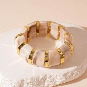 Detail of marble-patterned cream resin elastic bracelet with gold metal accents