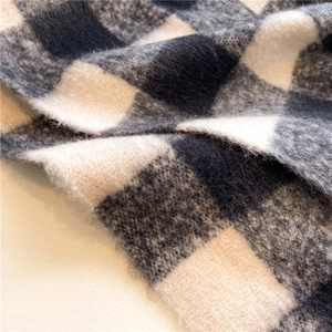 Close-up detail of soft black and white checkerboard cashmere-like scarf fabric texture