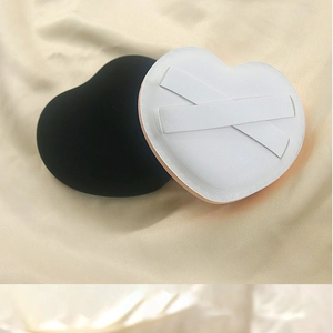 Detail of XL thick heart-shaped powder puffs in black velvet and white leather