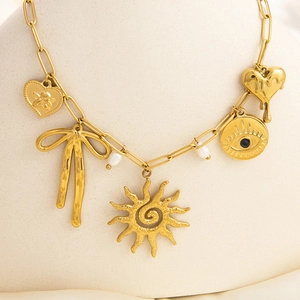 Detailed view of 18k gold plated sun and shell pendants necklace with pearls and charms