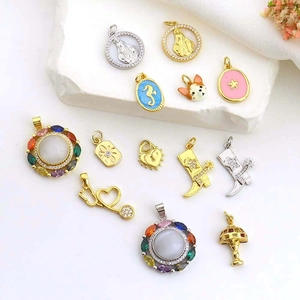 Detailed flat lay of luxury mixed metal pendants with gemstones and pearls on white stone