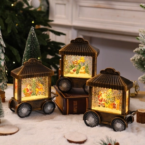 Detail of Christmas lantern with glowing LED Santa scene inside a bronze carriage