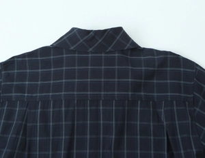 Close-up of navy plaid cotton shirt showing collar details and back box pleat construction