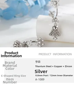 Detail of silver C-shape earring with snowflake pendant, zircon bow and hollow bell charms
