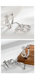 Macro detail of violin-shaped silver hoop earrings with sparkling zircon stones