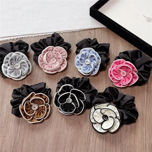Elegant satin camellia hair scrunchies set in multiple colors with white contrast edges