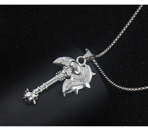 Macro detail of silver stainless steel viking axe pendant with embossed engravings on beads chain