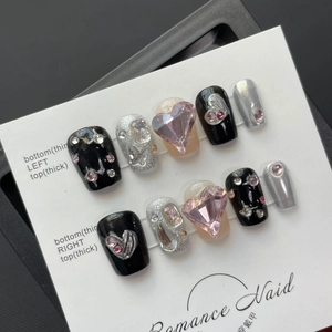 Short black and pink press-on nails with heart-shaped rhinestones on a white display card