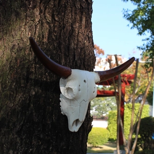 Resin bull skull wall hanging decor with realistic bone texture and long horns on a tree