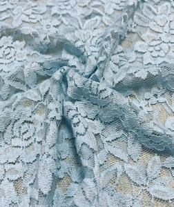 Detailed view of light blue lace fabric with floral patterns and hexagonal mesh texture