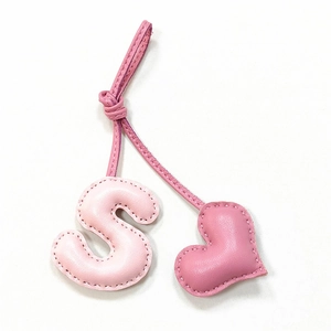 Pink leather bag charm with letter S and heart shape, handcrafted with fine stitching