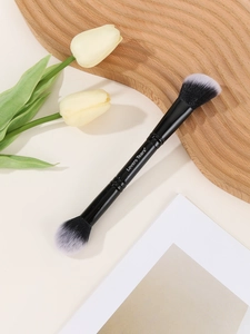 Dual-ended powder and contour brush with black and white gradient bristles on a tray