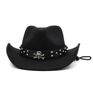 Detail of black felt cowboy hat featuring silver skull emblem and studded leather band