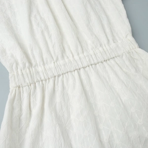 Détail de robe blanche avec broderie motif cœur et texture de taille élastique