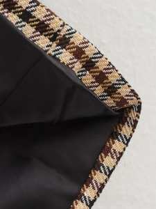 Detailaufnahme von braunem Tweed-Stoff mit Karomuster, schwarzem Futter und feiner Naht