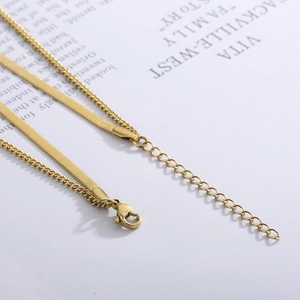 Detail of layered gold snake chain and cable link necklace with lobster clasp
