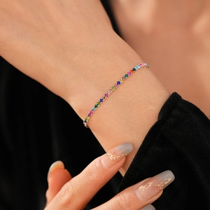 Dettaglio del bracciale elastico con strass arcobaleno al polso con finitura argento