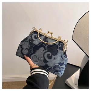 Close-up of blue denim clutch bag with metallic frame and auspicious cloud patterns