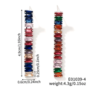 Détail de boucles d'oreilles cristal coloré montrant les dimensions de 4,9 cm par 0,6 cm