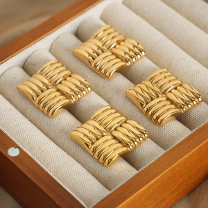 Polished gold-plated square earrings with woven texture displayed in a wooden jewelry box