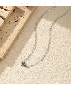 Macro detail of silver cross necklace featuring pave-set deep blue sapphire-like stones