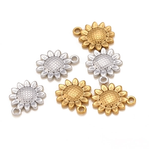 Detail view of sunflower charms in gold and silver steel for jewelry making