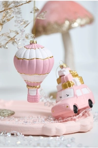 Pink Christmas ornaments featuring a hot air balloon and a car with gift boxes