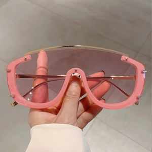 Close-up of pink oversized shield sunglasses with a metallic top bar and gradient lenses