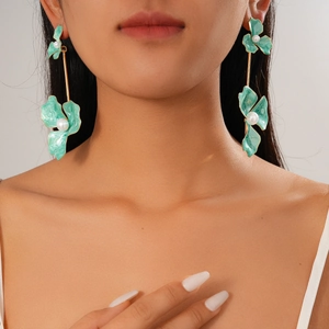 Detail of green floral enamel earrings with pearls on model, bohemian long drop design