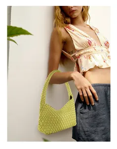 Detail of neon yellow woven leather hobo bag with a classic knotted handle design