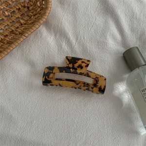 Macro detail of amber tortoise shell hair claw clip with rectangular hollow design