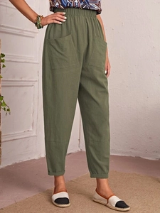 Detail view of military green cotton linen trousers with elastic waist and side pockets