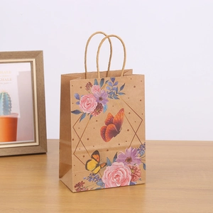 Kraft paper gift bag with floral butterfly print on a rustic wooden tabletop