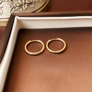 Detailed view of gold rope-knot hoop earrings placed inside a luxury jewelry box