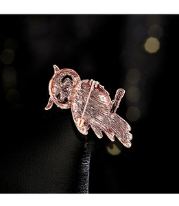 Macro view of rose gold owl brooch reverse showing textured metal and pin fastener