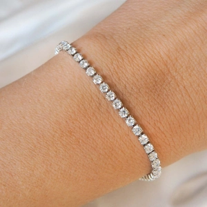 Detail shot of a silver single-row rhinestone necklace on a wrist with brilliant sparkle