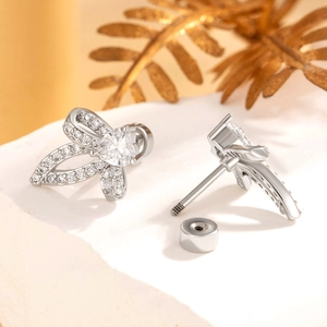 Elegant silver bow stud earrings with micro-set zircons and a central heart-shaped stone