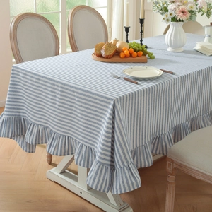 Blue and white striped linen tablecloth with decorative ruffled edges and Nordic style