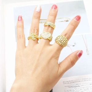 Set of four gold hollow heart and geometric rings with sparkling zircon inlay for women
