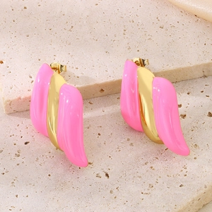 Détail macro de boucles d'oreilles ailées en émail rose et plaqué or 18 carats