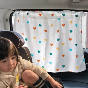 Car window sunshade with colorful heart pattern installed for child protection