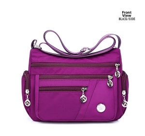Detail of purple waterproof nylon crossbody bag with multi-zippered pockets and metal logo