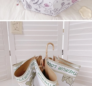 Detail of elegant folding umbrella with golden handle and decorative floral fabric patterns