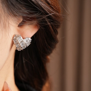 Gros plan de boucles d'oreilles cœur scintillantes avec zircons sur un modèle