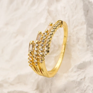 Detailed close-up of gold plated ring with marquise and round zircon on stone background