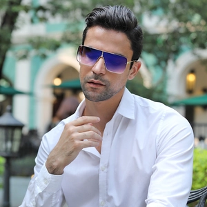 Detail of oversized square sunglasses with gradient lenses and gold metal frame on a man