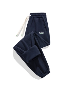 Dettaglio dei pantaloni sportivi in pile blu navy con coulisse e toppa con logo